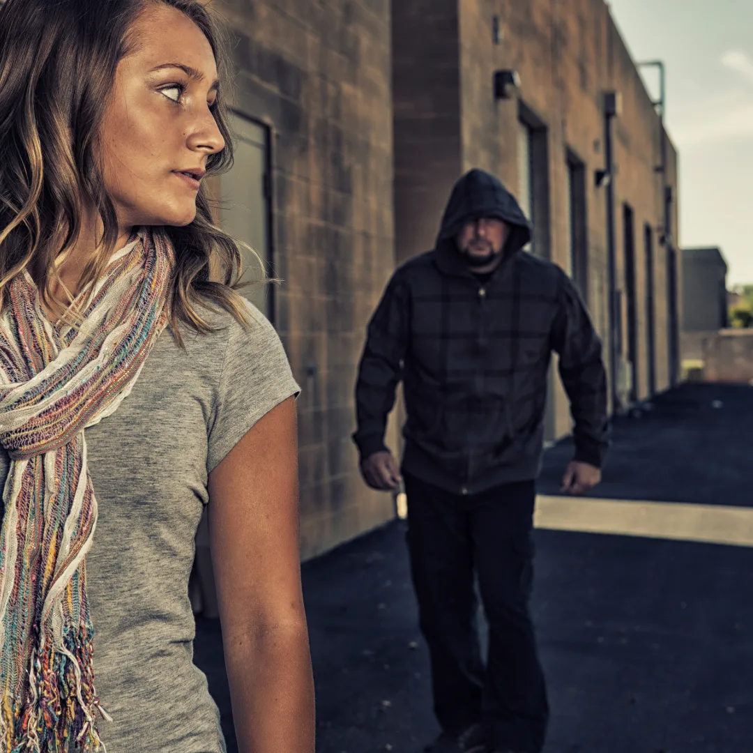 Woman noticing a potential risk while walking alone, illustrating personal safety awareness and prevention